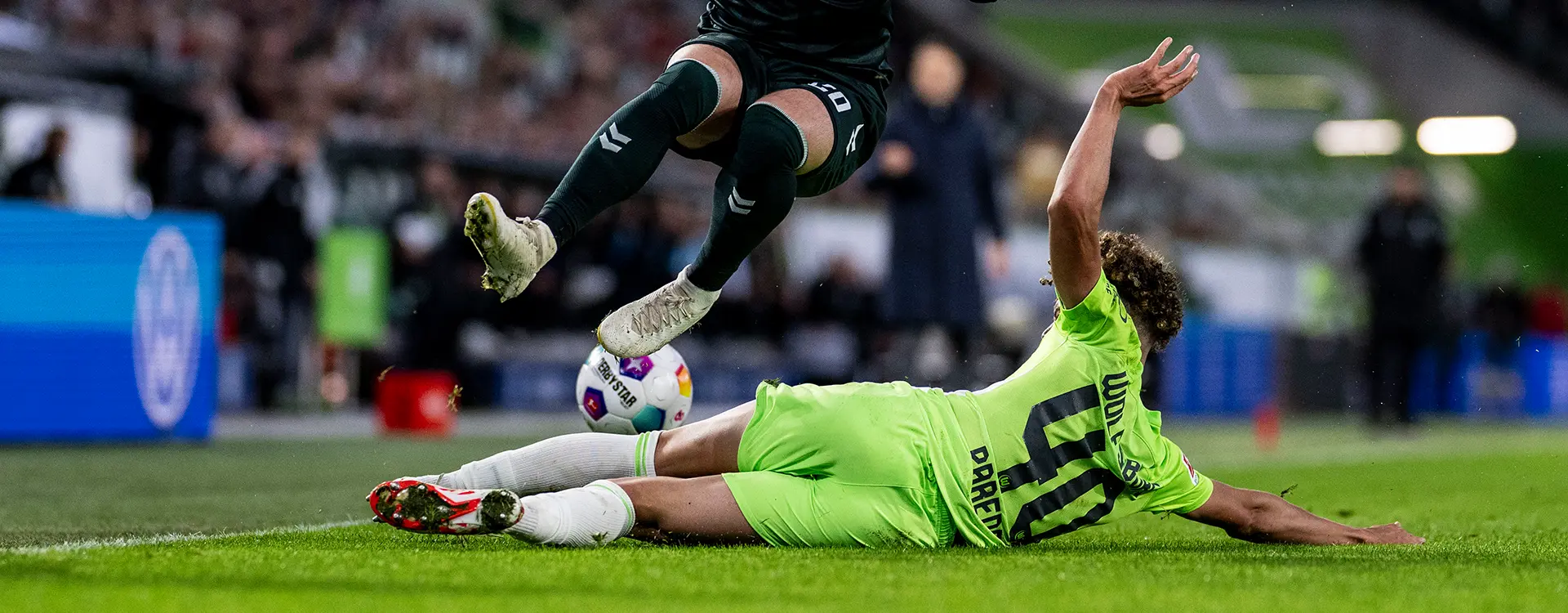 The image you've provided appears to be a composite of two separate photographs placed side by side. On the left, there is an action shot from a football (soccer) match, featuring a player in mid-air with a defensive posture as they intercept the ball, and another one on the ground, presumably in a shooting or dribbling situation.
On the right, there's a different scene, which seems to be edited into the image. It shows two people engaged in what looks like a street fight or altercation of some sort. The person on top is lying face downwards while another person seems to be falling backwards or sideways, away from themselves, indicating motion and action, and possibly indicating the individual has fallen or been pushed off their feet.
The juxtaposition creates a humorous or ironic contrast as the left image is typical of sports coverage showing a clash during a game of soccer, while the right image seems to suggest a very different type of conflict involving people with no visible protective gear, which would be unusual and potentially dangerous in the context of a sports event. The combination is likely meant to be comical or metaphorical, but without more context, it's hard to determine the intended message or purpose behind placing these images together.