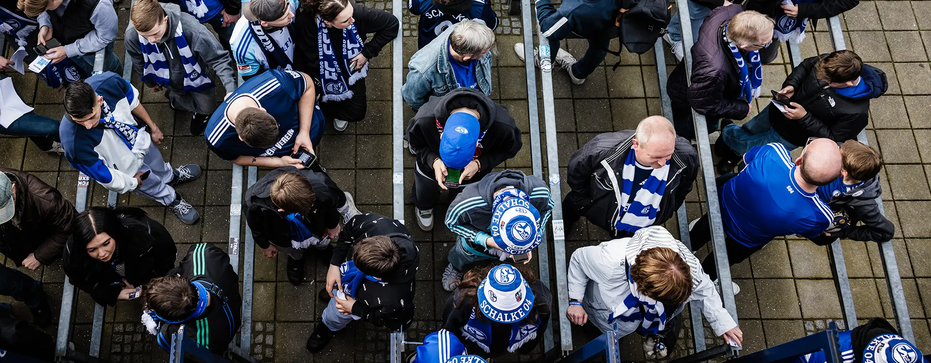 The image you've provided is quite blurry, which makes it difficult to discern specific details. It appears to be a photo of a crowd at what could be an event or sporting match, based on the large group of people clustered together. However, because of the lack of clarity and detail, it's hard to provide a more precise description or context. If you need information about elements within the image, please provide a clearer photo or more detailed description.