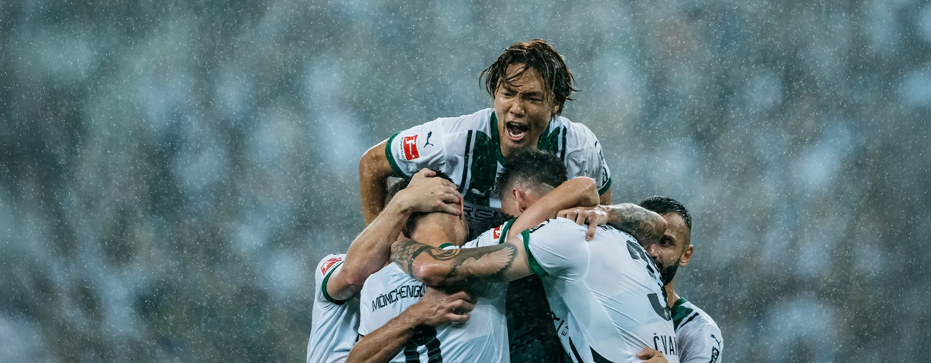 Ko Itakura von Borussia Mönchengladbach stützt sich auf jubelnde Mitspieler. (Foto)