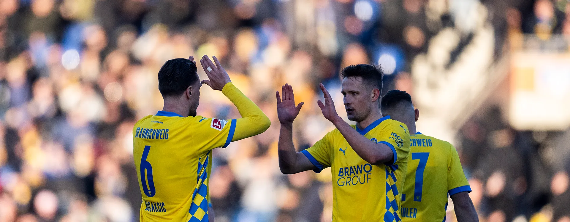 Zwei Spieler von Eintracht Braunschweig sind im Begriff, sich abzuklatschen. (Foto)