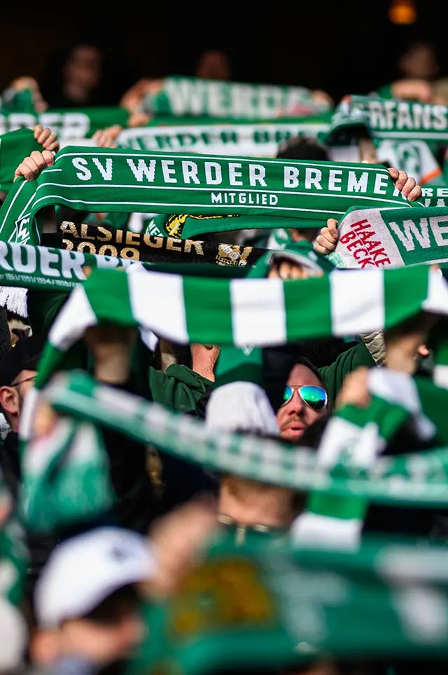SV Werder Bremen Fans halten die Schals ihrer Mannschaft hoch. (Foto)