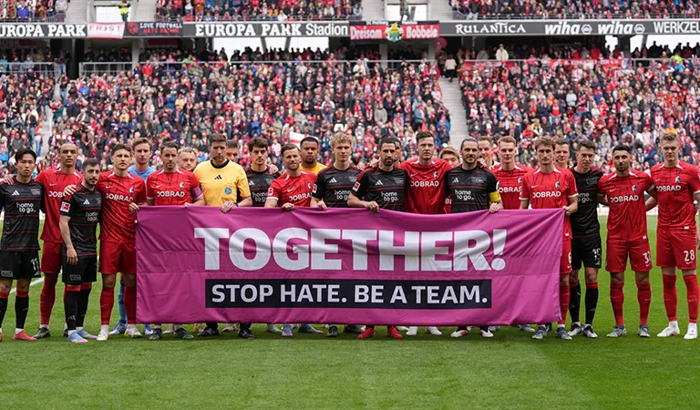 The teams from 1. FC Union Berlin and SC Freiburg hold up a banner together with the words: ‘TOGETHER! STOP HATE. BE A TEAM.’. (Photo)