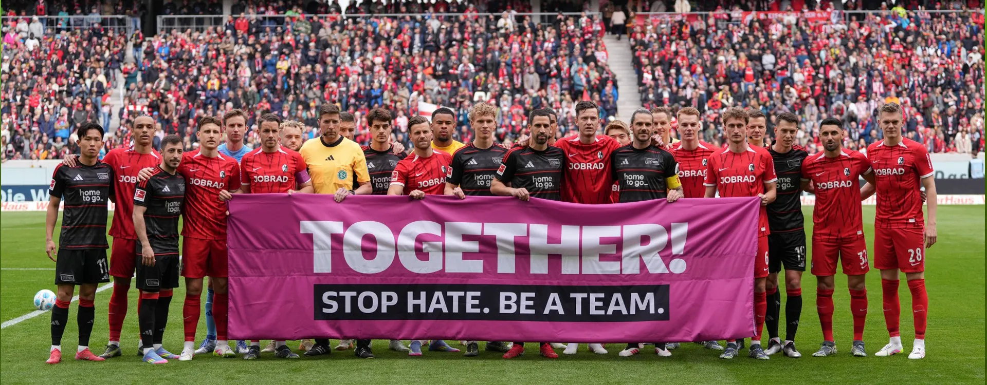The teams from 1. FC Union Berlin and SC Freiburg hold up a banner together with the words: ‘TOGETHER! STOP HATE. BE A TEAM.’. (Photo)