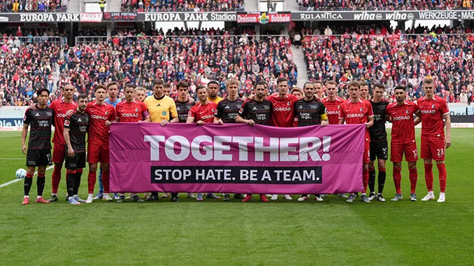 The teams from 1. FC Union Berlin and SC Freiburg hold up a banner together with the words: ‘TOGETHER! STOP HATE. BE A TEAM.’. (Photo)