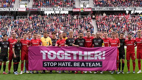 The teams from 1. FC Union Berlin and SC Freiburg hold up a banner together with the words: ‘TOGETHER! STOP HATE. BE A TEAM.’. (Photo)
